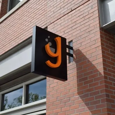 Double-sided projecting blade sign mounted on a brick storefront