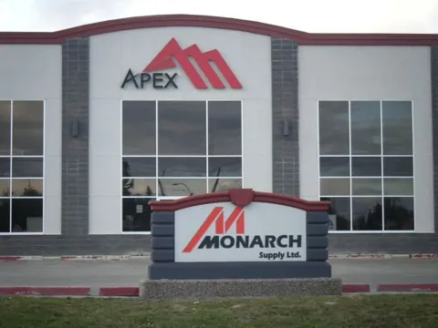 Building-mounted business logo paired with a freestanding property sign