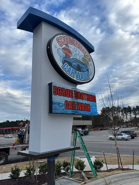 Freestanding illuminated business sign with an electronic message panel
