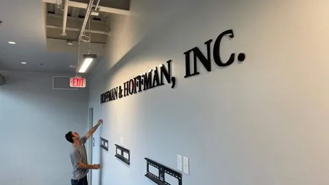 Dimensional company lettering mounted on an interior office wall